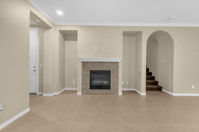 unfurnished living room featuring ornamental molding and a tiled fireplace