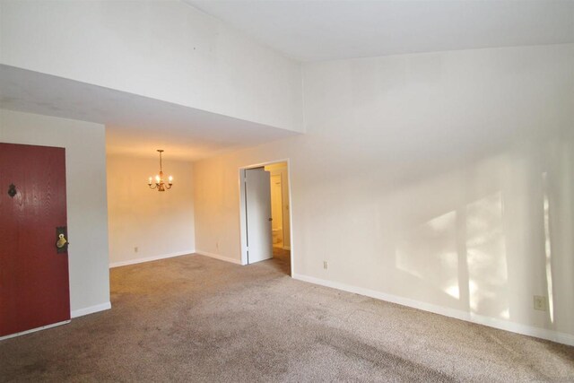 carpeted spare room with a chandelier