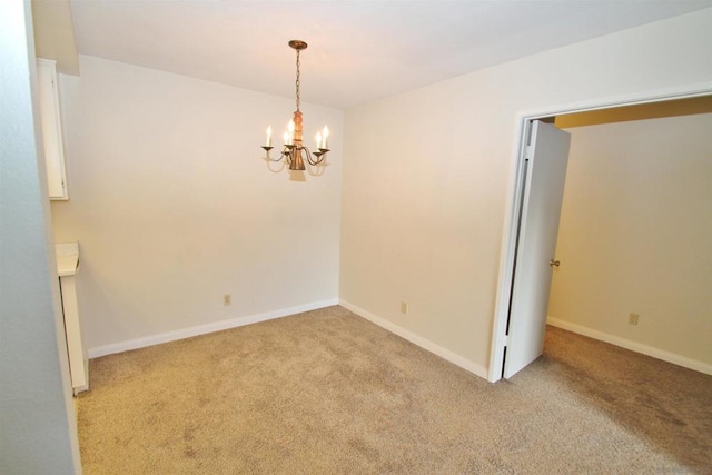 spare room with light colored carpet and a notable chandelier