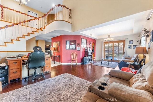 home office with a raised ceiling, a notable chandelier, and dark hardwood / wood-style floors