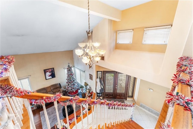 tiled foyer featuring french doors, an inviting chandelier, and vaulted ceiling with beams