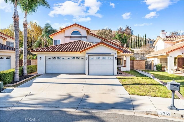 mediterranean / spanish-style home with a front lawn and a garage