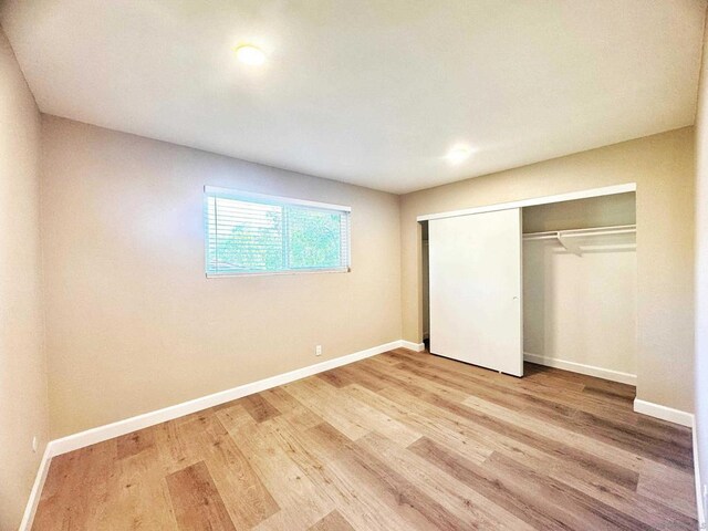 unfurnished bedroom featuring a closet and light hardwood / wood-style floors