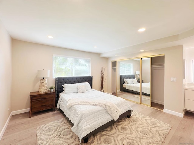 bedroom with multiple windows, a closet, and light wood-type flooring