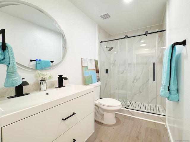 bathroom featuring toilet, hardwood / wood-style floors, vanity, and an enclosed shower