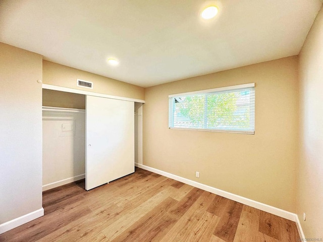 unfurnished bedroom with a closet and light wood-type flooring