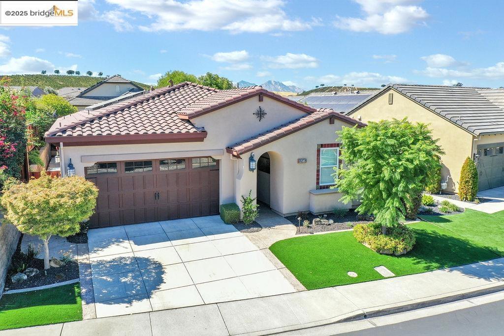 mediterranean / spanish-style home featuring a front lawn and a garage