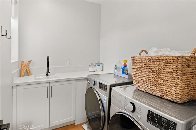 laundry room featuring sink, separate washer and dryer, and cabinets