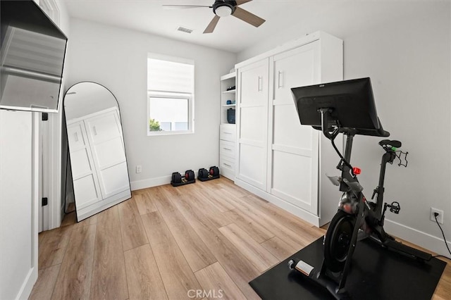 exercise room with ceiling fan and light hardwood / wood-style flooring