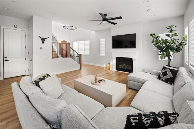 living room featuring ceiling fan, plenty of natural light, and light wood-type flooring