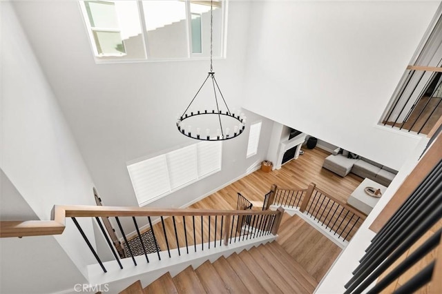 stairway featuring an inviting chandelier and hardwood / wood-style flooring