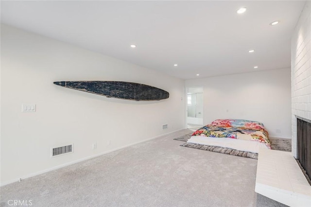 carpeted bedroom with a brick fireplace