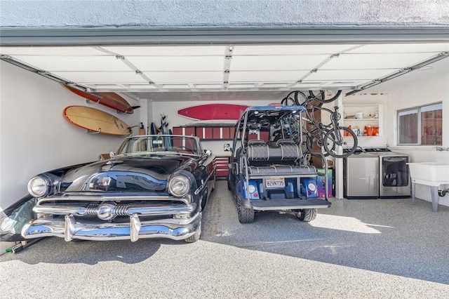 garage with independent washer and dryer and sink