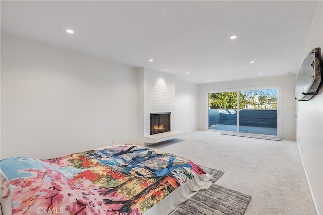 bedroom featuring access to exterior, carpet floors, and a fireplace