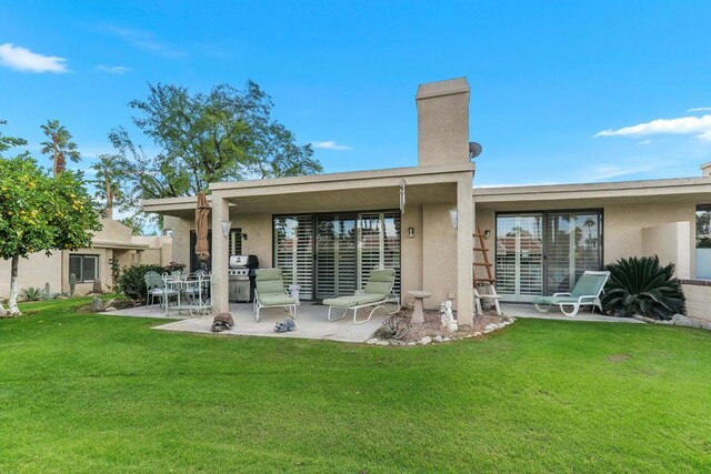 back of house with a patio area and a yard