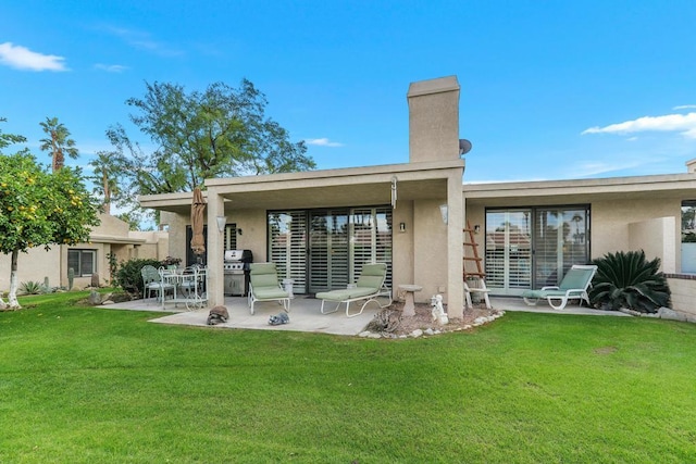 back of property with a patio area and a lawn