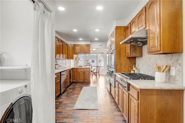 kitchen featuring stainless steel appliances, backsplash, and washer / clothes dryer