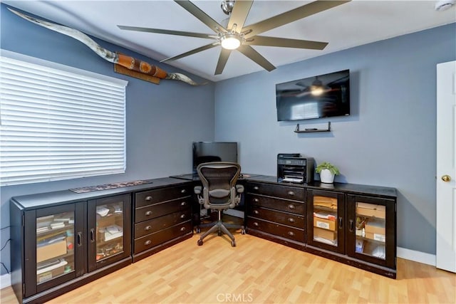 home office with light wood-type flooring and ceiling fan