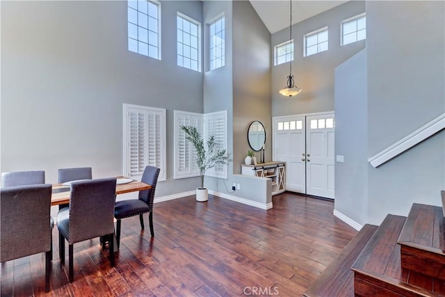 dining room with dark hardwood / wood-style floors and a high ceiling