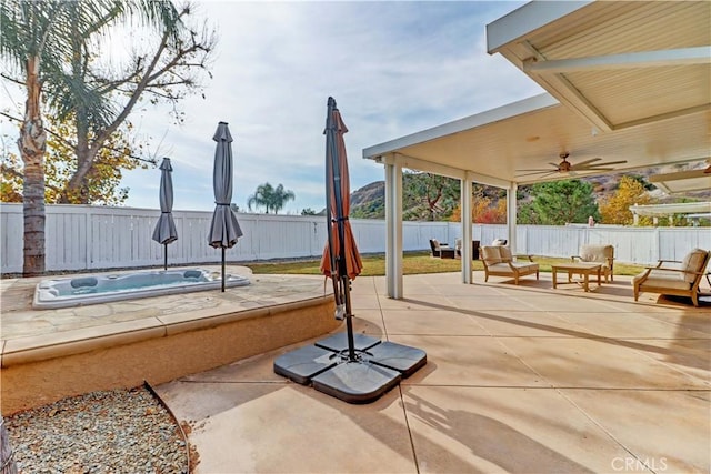 view of patio / terrace with ceiling fan, an outdoor living space, and an outdoor hot tub