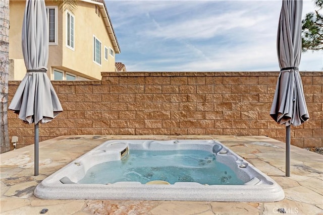 view of swimming pool featuring a hot tub and a patio area