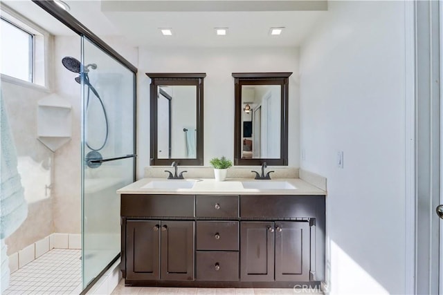 bathroom with vanity and a shower with door