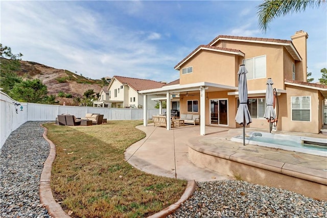 rear view of house with a patio area, outdoor lounge area, a yard, and ceiling fan