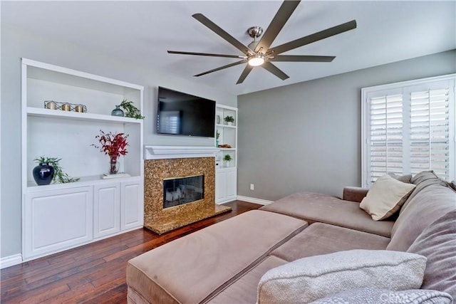 bedroom with ceiling fan, dark wood-type flooring, and a fireplace