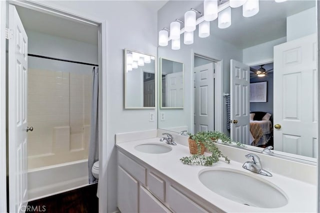 full bathroom featuring toilet, ceiling fan, vanity, and shower / bath combo with shower curtain