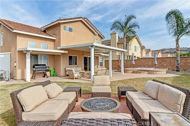 back of property with a patio area and an outdoor living space with a fire pit