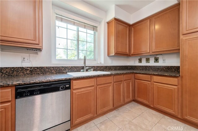 kitchen featuring sink, dishwasher, dark stone counters, and light tile patterned flooring