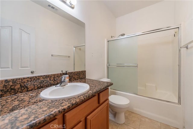 full bathroom with shower / bath combination with glass door, vanity, toilet, and tile patterned flooring