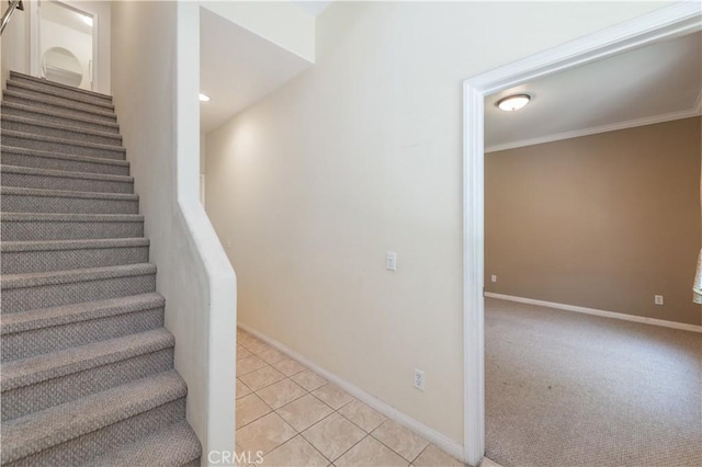 staircase with tile patterned floors and crown molding