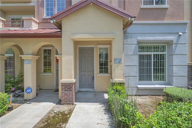 13637 Foster Ave Unit 5, Baldwin Park, CA 91706 - view of exterior entry with a standing seam roof, stucco siding, and metal roof