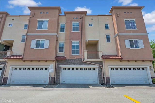 13637 Foster Ave Unit 5, Baldwin Park, CA 91706 - view of front facade featuring stucco siding, a standing seam roof, stone siding, and a garage