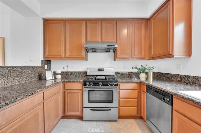 13637 Foster Ave Unit 5, Baldwin Park, CA 91706 - kitchen with under cabinet range hood, appliances with stainless steel finishes, dark stone counters, and light tile patterned floors