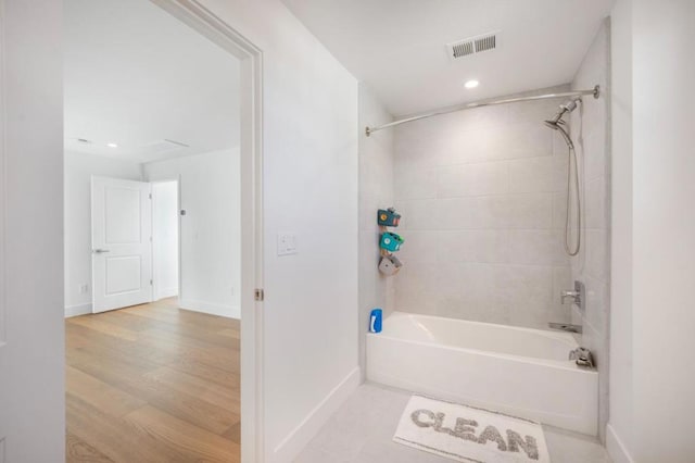 bathroom featuring tiled shower / bath and wood-type flooring