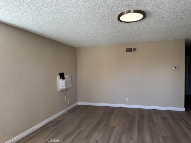 unfurnished room with a textured ceiling and dark hardwood / wood-style flooring