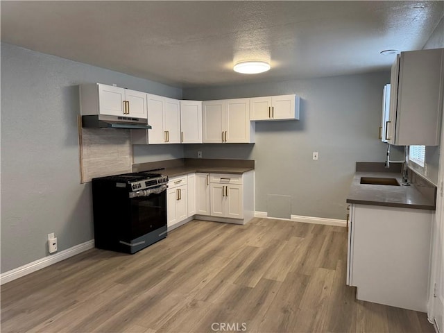 kitchen with stainless steel range with gas cooktop, white cabinetry, sink, and a textured ceiling