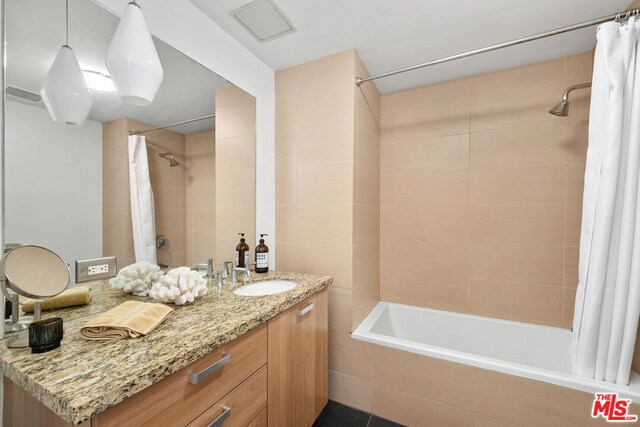 bathroom with shower / tub combo and vanity