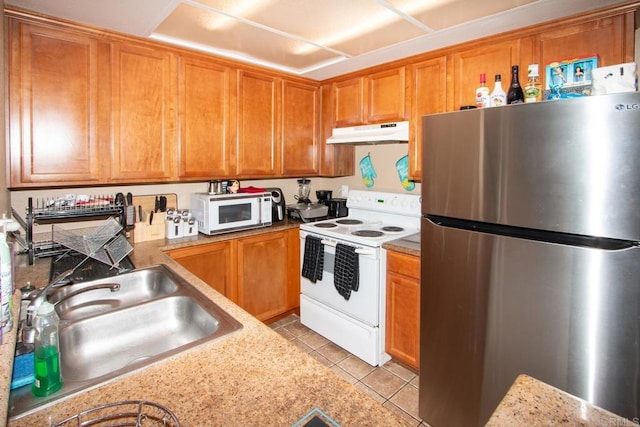 kitchen with sink, white appliances, light stone countertops, and light tile patterned flooring