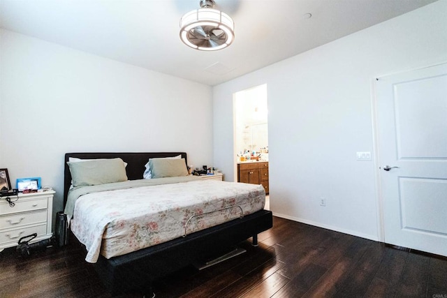 bedroom featuring ensuite bathroom and dark hardwood / wood-style flooring