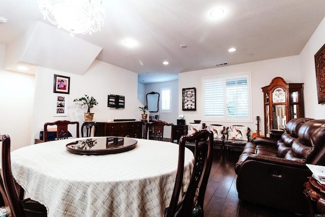 dining room with dark wood-type flooring and a chandelier