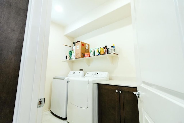 clothes washing area with light tile patterned floors and washer and clothes dryer