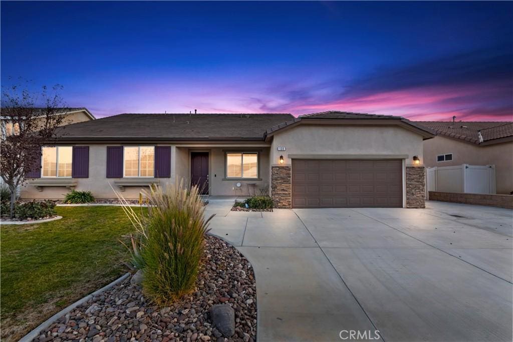 ranch-style house with a yard and a garage