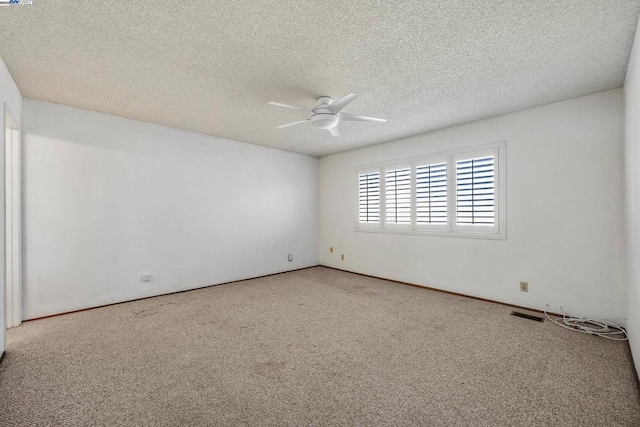 carpeted spare room featuring a textured ceiling and ceiling fan