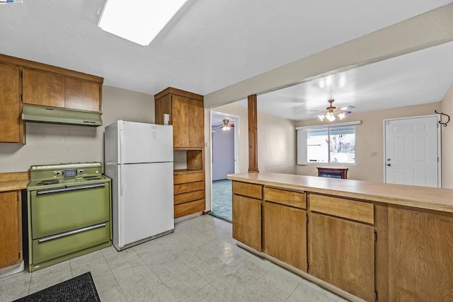 kitchen with white refrigerator, range, ceiling fan, and kitchen peninsula