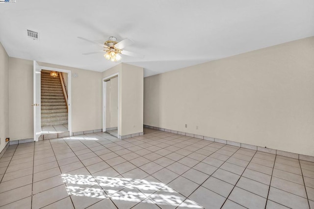 tiled spare room featuring ceiling fan