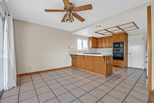 kitchen with light tile patterned floors, black appliances, a kitchen bar, decorative backsplash, and kitchen peninsula