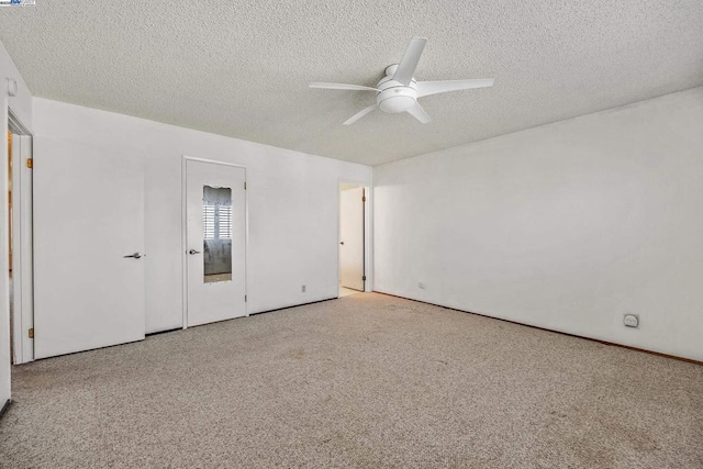 unfurnished bedroom featuring ceiling fan, light colored carpet, and a textured ceiling